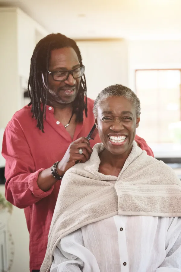 Woman smiling while getting her hair fixed at the salon located inside the care facility