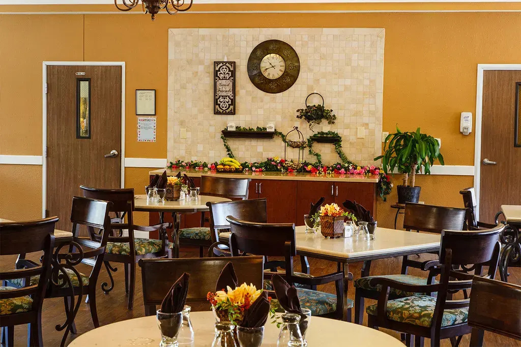 Town East Rehab dining area with multiple wheelchair accessible tables that have small fresh flower vases on each