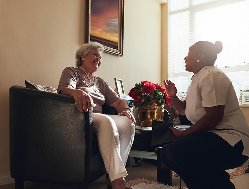 Nurse sitting with patient explaining care