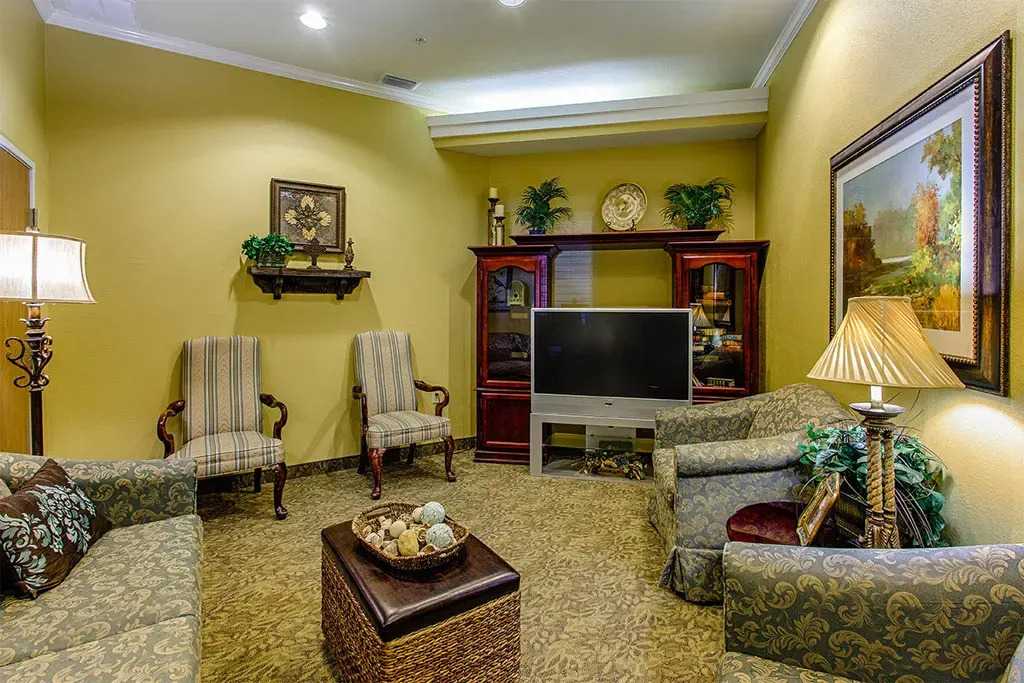 A cozy seating area with a sofa and bookshelves in Mesquite, TX at Town East Rehab 